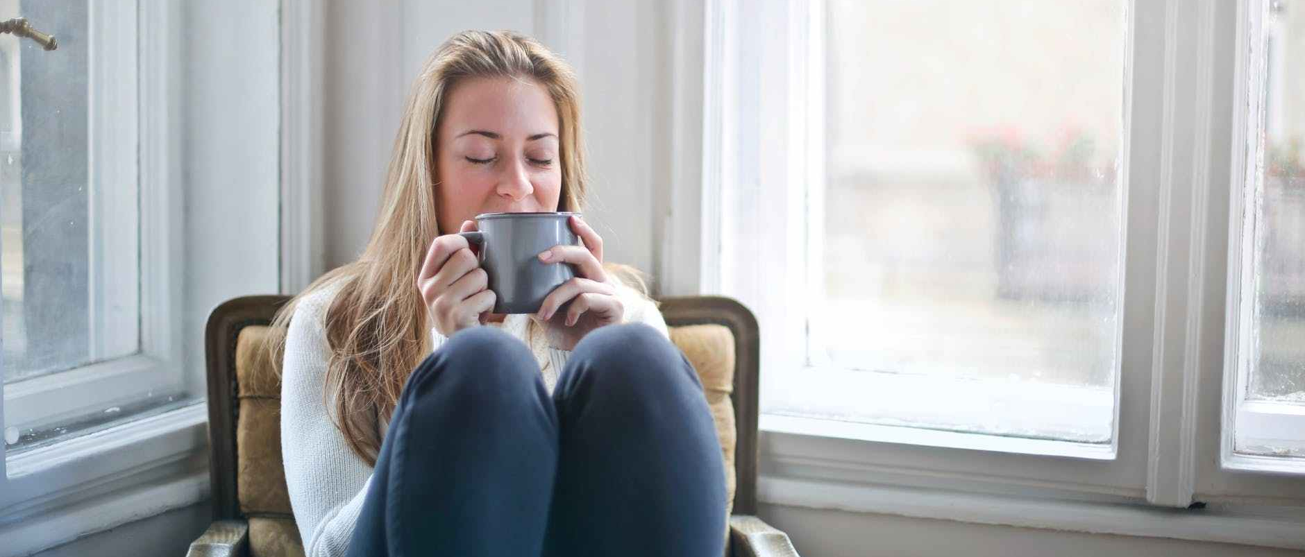 woman holding gray ceramic mug