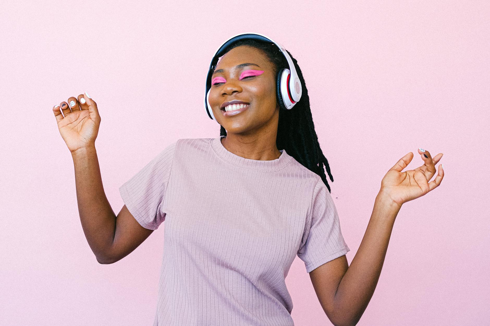 A woman wearing headphones and dancing whilst smiling. (wallflowerhaze.com)