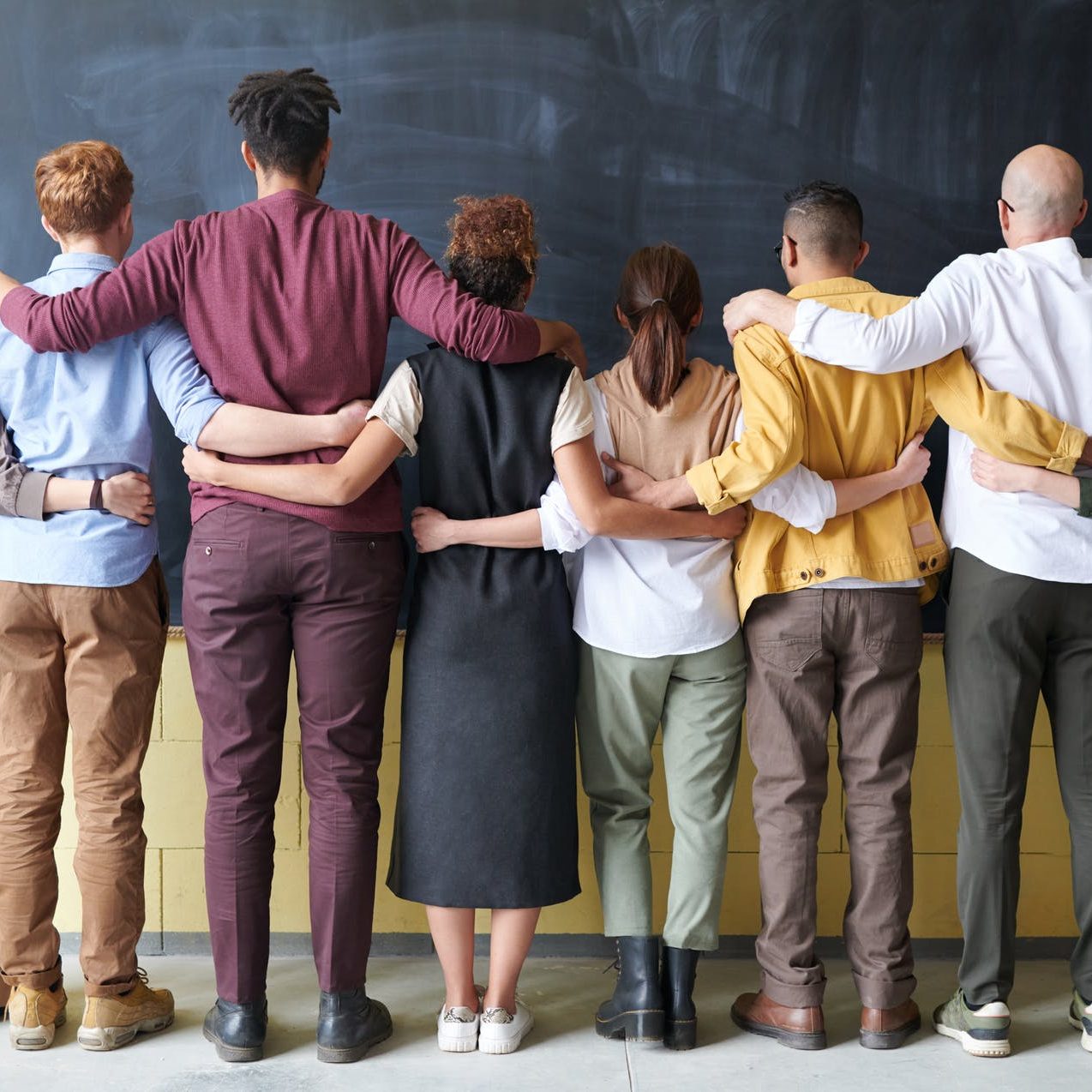 A group of people in a line, with their arms around each other's waists. (wallflowerhaze.com)