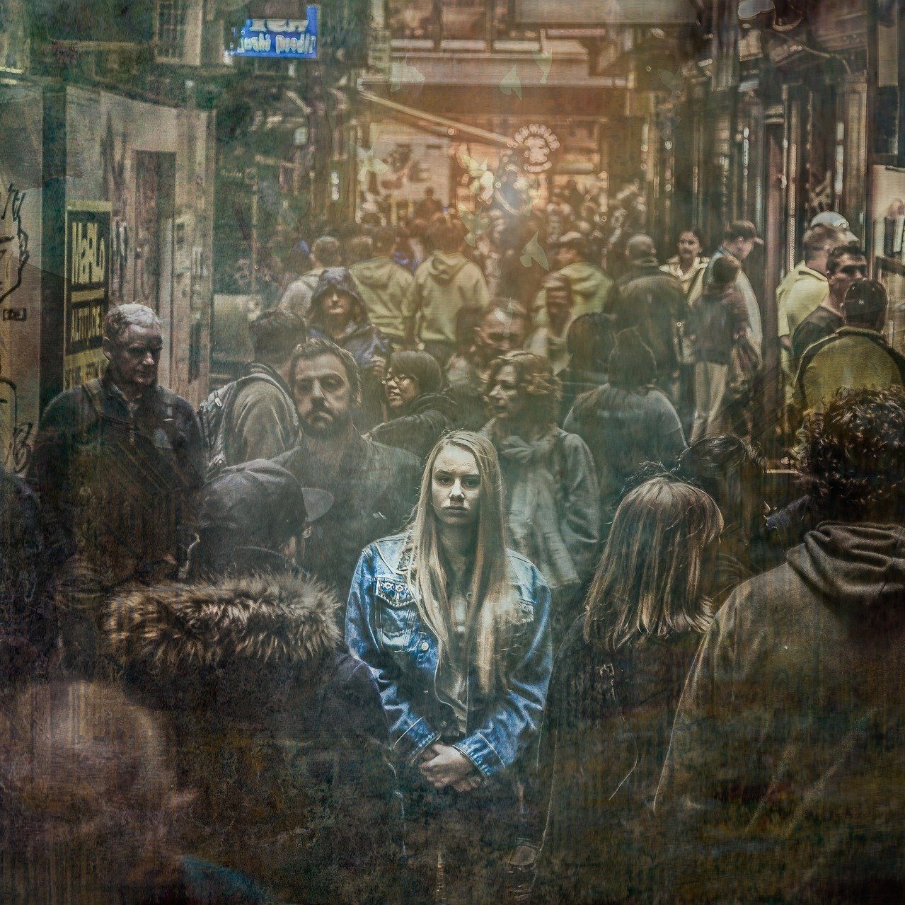 A woman standing in a crowded street. The focus is blurry and the lighting illuminates the woman more than the people bustling around her. (wallflowerhaze.com)