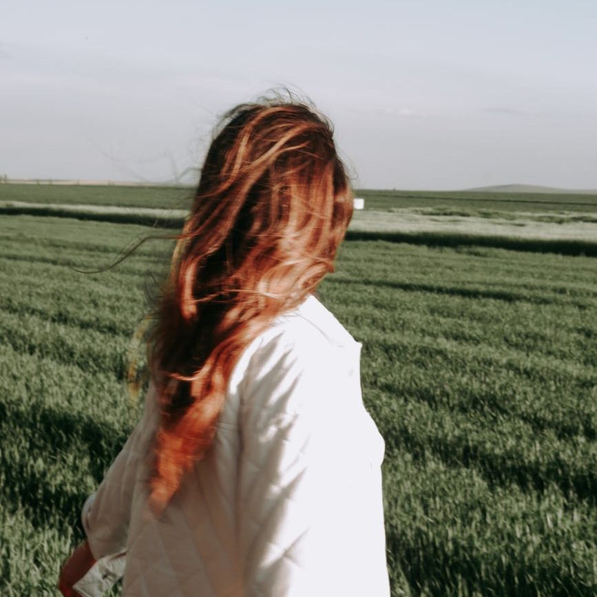 A woman looking away, her hair flowing in the wind. (wallflowerhaze.com)