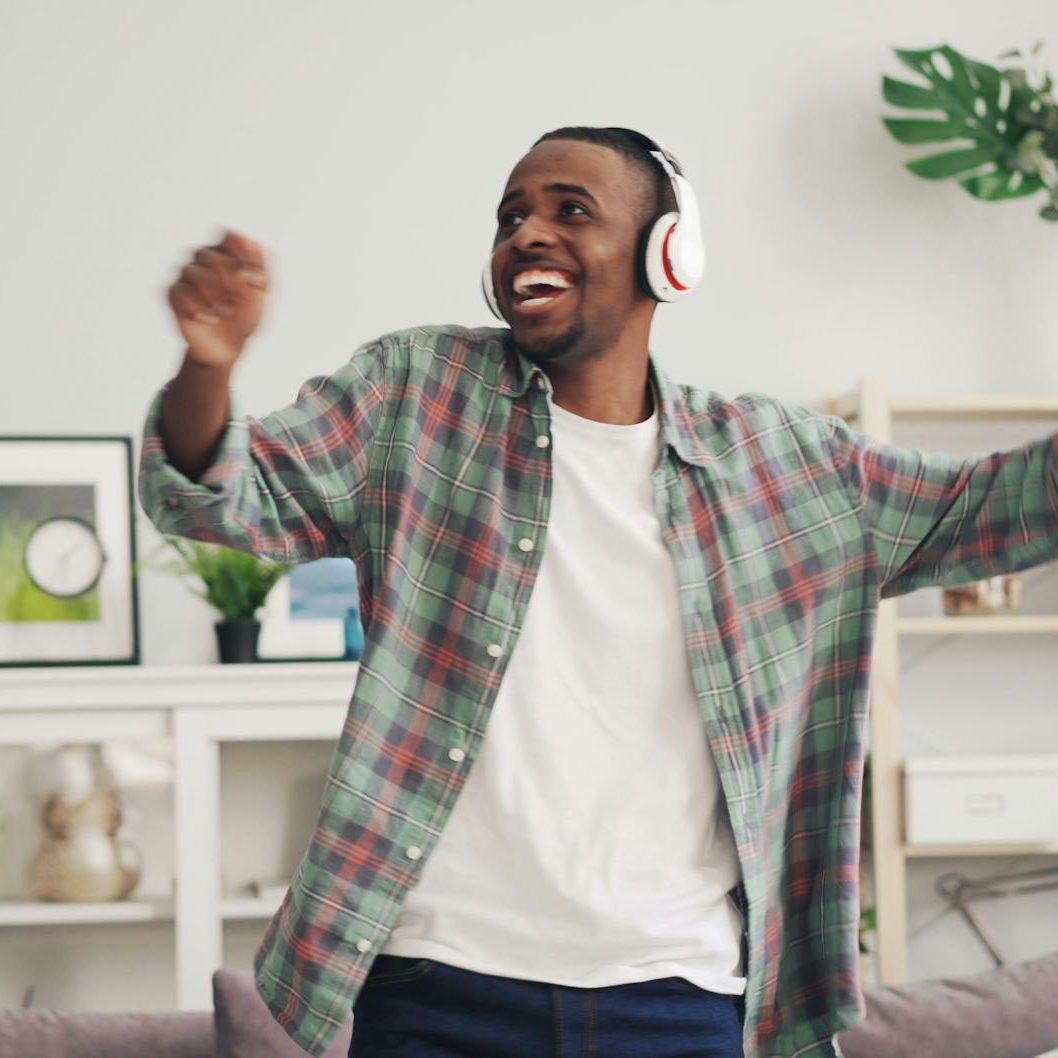 A man wearing headphones, dancing and smiling. (wallflowerhaze.com)