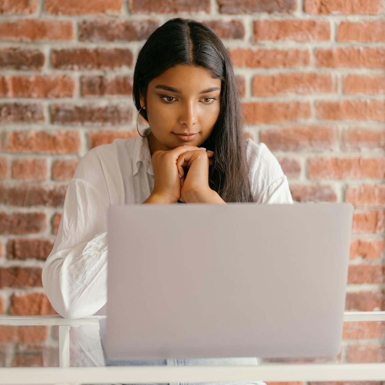A woman watching a laptop screen. (wallflowerhaze.com)